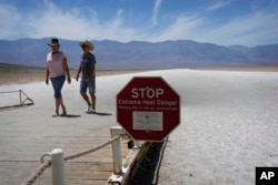 A sign warns visitors of extreme heat danger at Badwater Basin, Sunday, July 16, 2023, in Death Valley National Park, Calif. Death Valley's brutal temperatures come amid a blistering stretch of hot weather that has put roughly one-third of Americans under some type of heat advisory, watch or warning. (AP Photo/John Locher)