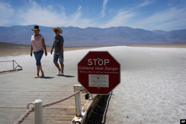 A sign warns visitors of extreme heat danger at Badwater Basin, Sunday, July 16, 2023, in Death Valley National Park, Calif. Death Valley's brutal temperatures come amid a blistering stretch of hot weather that has put roughly one-third of Americans under some type of heat advisory, watch or warning. (AP Photo/John Locher)