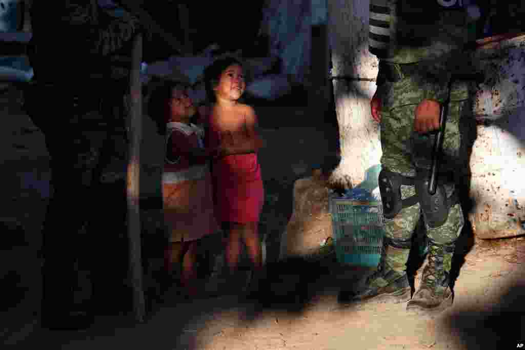 Honduran migrant girls play near Mexican National Guards where Central American migrants camp on the Mexican shore of the Suchiate River on the border with Guatemala, near Ciudad Hidalgo, Mexico.