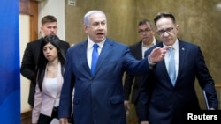FILE - Israeli Prime Minister Benjamin Netanyahu, center, arrives to attend the weekly Cabinet meeting in Jerusalem, March 17, 2019. 
