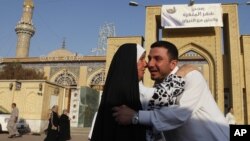 Iraqi Sunni Muslims exchange greetings after Eid prayers outside Abu Hanifa mosque at the first day of Eid al-Fitr prayers in Baghdad, Iraq, August 19, 2012. 