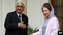 Indian Foreign Minister Salman Khurshid, left, prepares to shake hands with Bangladesh's opposition leader Khaleda Zia as they pose for the media before a meeting in New Delhi, India, October 30, 2012.
