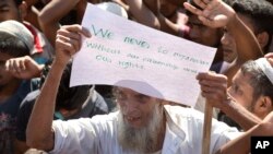 An elderly Rohingya refugee holds a placard during a protest against the repatriation process at Unchiprang refugee camp near Cox's Bazar, in Bangladesh, Nov. 15, 2018. 