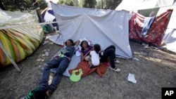 A Venezuelan refugee family rests outside a makeshift camp before going out to find any kind of work in Quito, Ecuador, August 9, 2018.