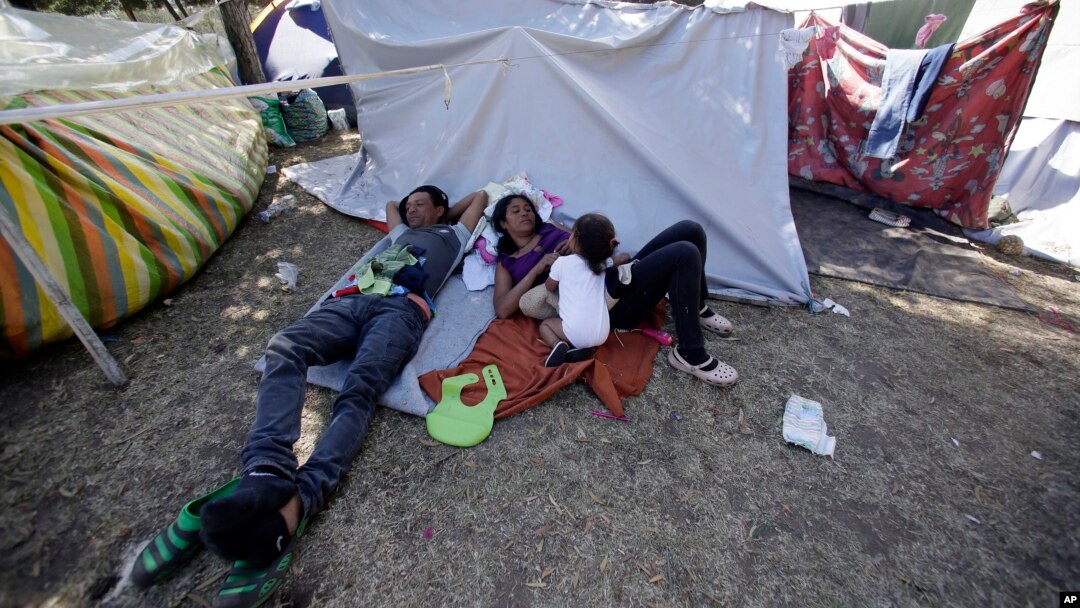 A Venezuelan refugee family rests outside a makeshift camp before going out to find any kind of work in Quito, Ecuador, Aug. 9, 2018.
