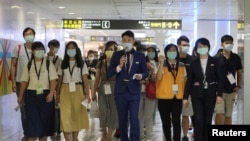FILE - People who want to leave the island, but cannot due to COVID-19 travel restrictions, take part in a 'fake' travel experience for tourists simulating the experience of using an international airport at Songshan airport in Taipei, July 2, 2020. 