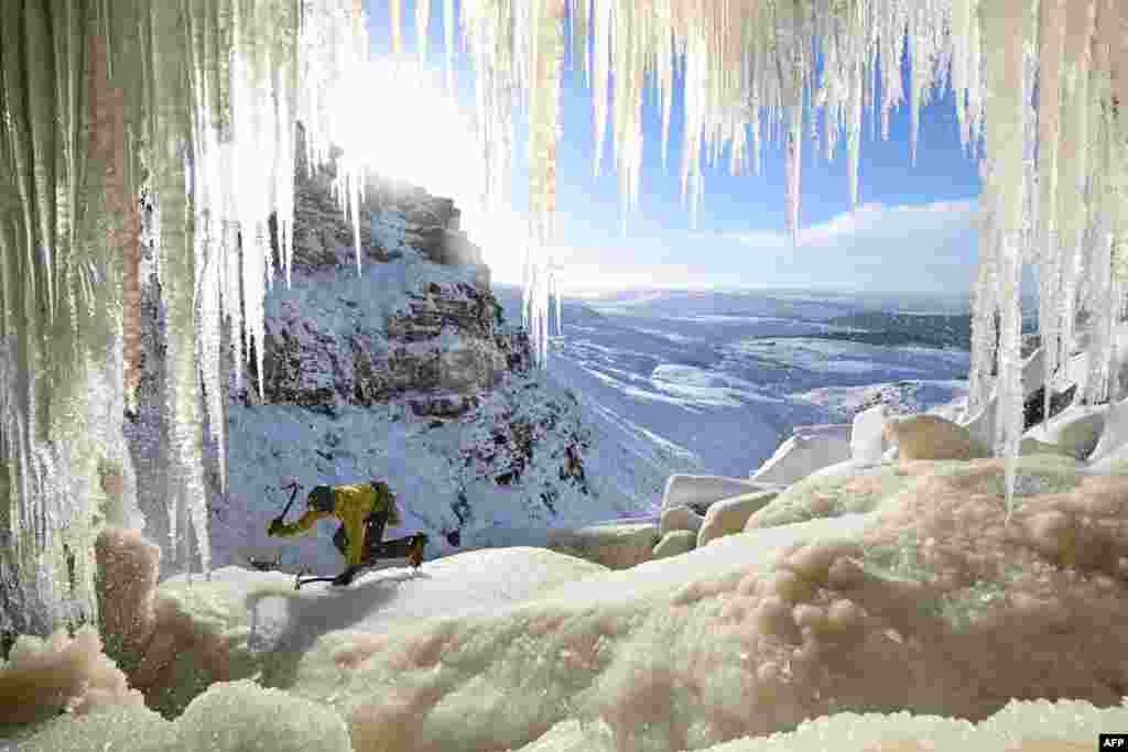 An ice climber ascends Kinder Downfall, a frozen waterfall in the Peak District National Park, near Hayfield, in north-west England as temperatures in the region plummet.