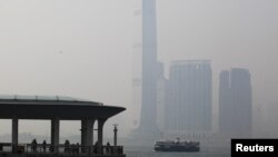 People rest at a ferry pier at the financial Central district under hazy weather in Hong Kong August 1, 2012. In the background, is the city's highest building, the International Commerce Centre in Kowloon peninsula. 