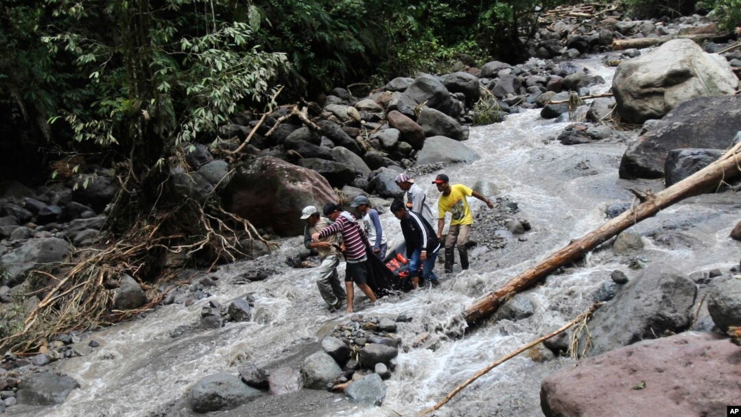 Regu penyelamat tengah membawa korban banjir yang melanda air terjun Dua Warna di Sibolangit, Sumatra Utara (16/5).