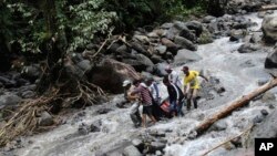 Para petugas mengangkat korban banjir bandang yang melanda air eerjun Dua Warna, Sibolangit, Sumatra Utara (Foto: dok).