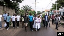 Un homme tient une croix lors d'une manifestation près de l'église François De Sales, à Kinshasa, le 25 février 2018.