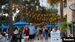 FILE - People walk without masks on Beach Drive in downtown St. Petersburg, Florida, amid the coronavirus pandemic, Aug. 6, 2021. 