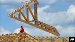 In this July 17, 2014 photo, construction workers build a commercial complex in Springfield, Illinois.