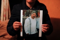 Rebeca Valencia Gonzalez holds a picture of her husband, environmental activist Homero Gomez Gonzalez, in their home in Ocampo, Michoacan state, Mexico, Jan. 30, 2020.