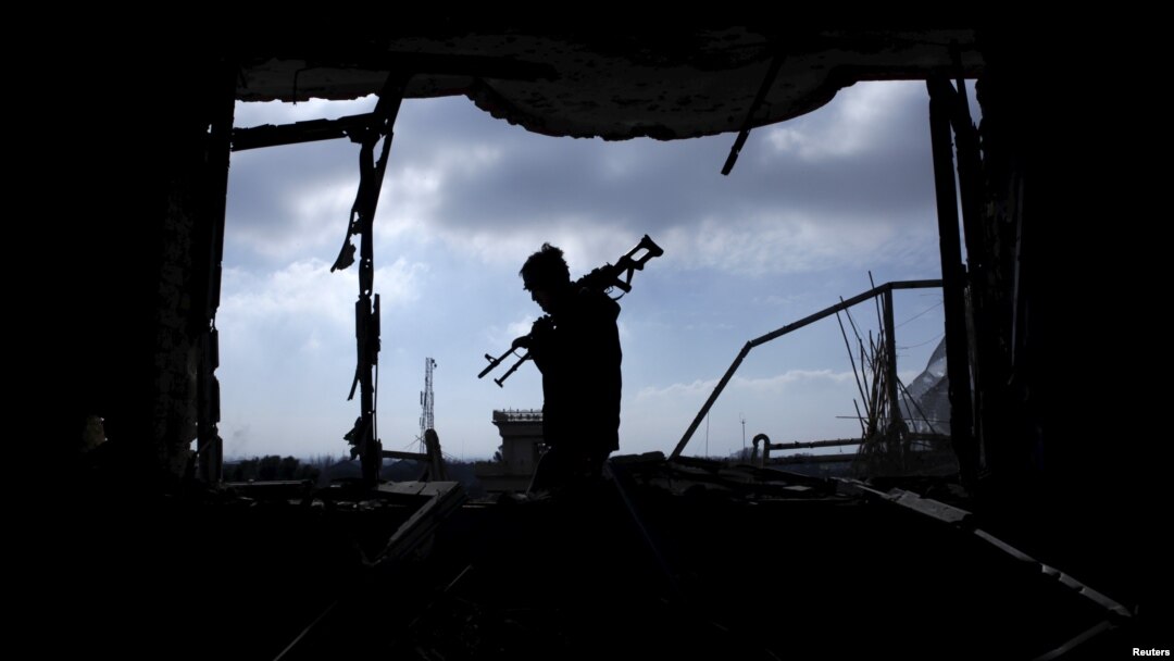 FILE - An Afghan policeman inspects a building used by insurgents after an operation near the Indian consulate in Mazar-i-Sharif, Afghanistan, Jan. 5, 2016. 