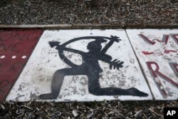 In this July 28, 2020, file photo, Native American imagery is painted on the walkway of a Utah high school. New York has banned the use of similar mascots in all public schools.
