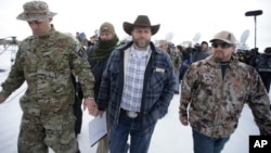 Ammon Bundy, center, one of the sons of Nevada rancher Cliven Bundy, walks off after speaking with reporters during a news conference at Malheur National Wildlife Refuge headquarters Jan. 4, 2016, near Burns, Ore. 