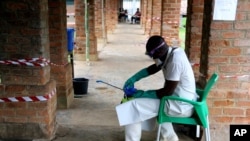 FILE - A health worker in protective gear prepares a disinfectant sprayer at a treatment center in Bikoro, Equateur province, Democratic Republic of Congo, May 13, 2018, during an earlier Ebola outbreak. 
