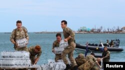 Members of the Humanitarian and Disaster Relief team from the Royal Fleet Auxiliary's RFA Mounts Bay deliver supplies after Hurricane Dorian on the island of Great Abaco, Bahamas, Sept. 4, 2019.