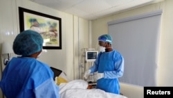 FILE - Doctor Oluwajoba Oroge attends to a patient at EHA Clinics in Abuja, Nigeria, Jan. 14, 2021.