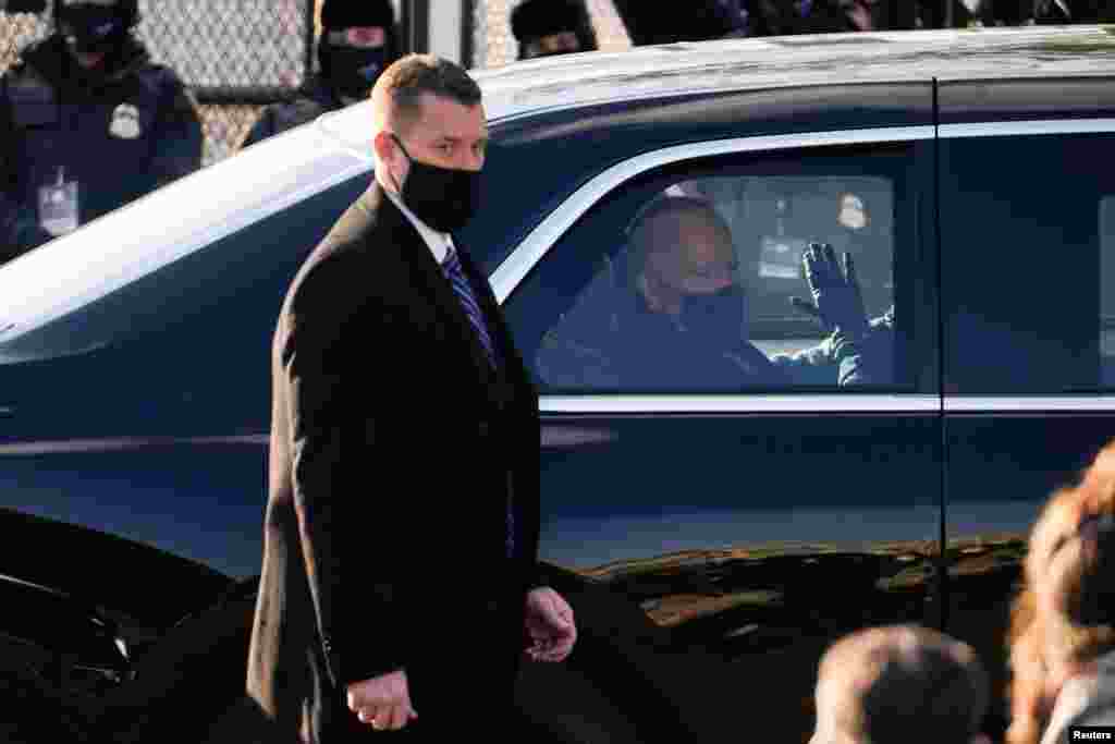 U.S. President Joe Biden waves through the window of a car during the Inauguration Day parade, in Washington, Jan. 20, 2021. 