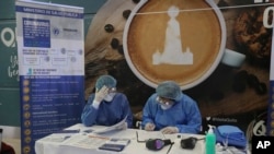 Health Ministry staffers prepare informational packets for travelers who are arriving on an international flights at the Mariscal Sucre Airport, in Quito, Ecuador, Feb. 29, 2020. 