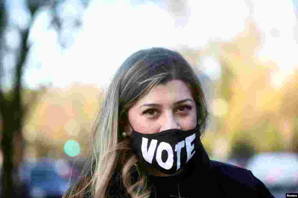 A woman wears a mask with a sign &quot;VOTE&quot; on the day of the 2020 U.S. presidential election in Washington, Nov. 3, 2020. 