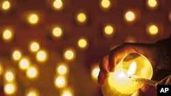 Woman lights candle at 'night of lights' ecumenical prayer, Erfurt, Germany, Nov. 23, 2011 (file photo).