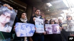 Activists and relatives take part in a protest demanding the whereabouts of four activists who disappeared during the war between opposition groups and former President Bashar al-Assad's forces, in Douma, Syria, Jan. 1, 2025.