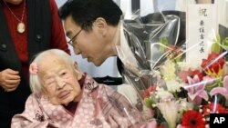 Misao Okawa diberi ucapan selamat oleh kepala rumah jompo di Osaka, sehari sebelum ulangtahunnya pada 5 Maret 2015. (AP/Kyodo News)