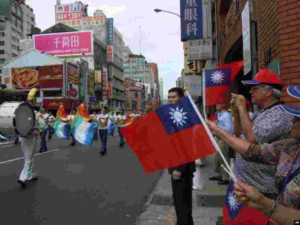 民眾在台北市街頭揮舞中華民國國旗觀看儀仗隊表演