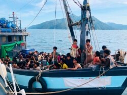 FILE- In this handout photo released on April 5, 2020 by the Malaysian Maritime Enforcement Agency, a wooden boat carries suspected Rohingya migrants detained in Malaysian territorial waters off the island of Langkawi.