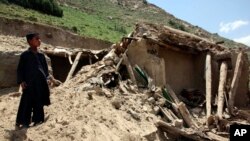 Seorang anak tengah berdiri di depan sebuah rumah yang hancur terkena gempa di Baghlan, utara Kabul, Afghanistan (26/10).