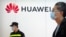 Seorang petugas keamanan tampak berjaga di dekat stan Huawei dalam sebuah ekshibisi di Beijing, China, pada 28 Spetember 2021. (Foto: AP/Mark Schiefelbein)