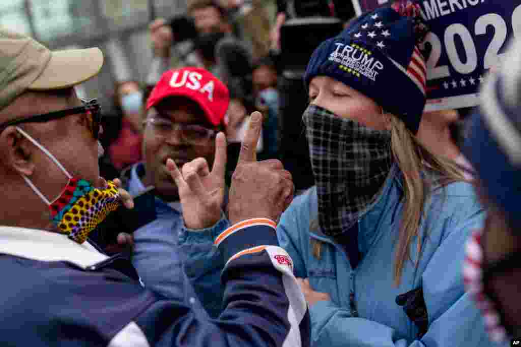 U.S. President Donald Trump&#39;s supporters, right, argue with a counter demonstrator, left, as they protest election results outside the central counting board at the TCF Center in Detroit, Michigan.