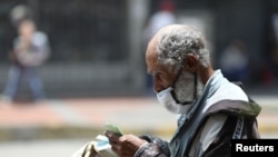 Un anciano caminando por Caracas después de que el gobierno en disputa relajara las medidas de la cuarentena para hacer frente al brote del coronavirus.