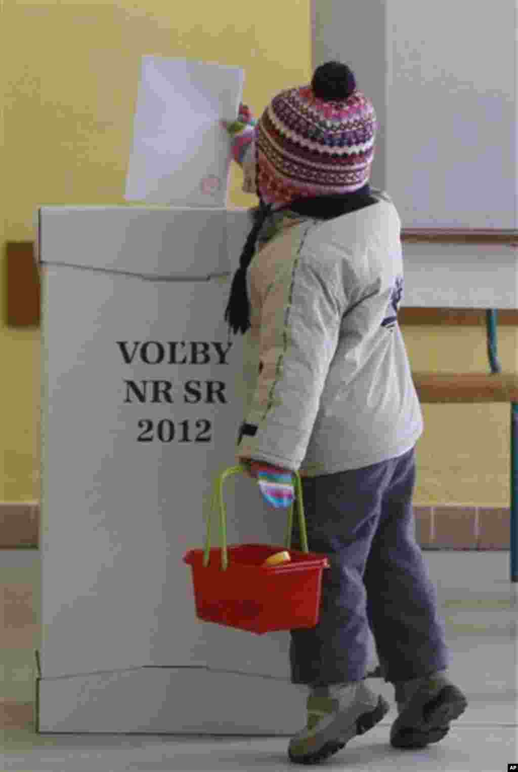 A child puts a vote in a ballot box during a general election in Bratislava, Slovakia, Saturday, March 10, 2012. (AP Photo/Petr David Josek)