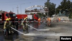 在喀布尔机场主要入口受到一枚汽车炸弹的袭击后阿富汗工人清理爆炸现场。（2015年8月10日） 