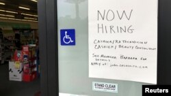 A handwritten hiring sign is posted outside a local drugstore in Solana Beach, California, July 17, 2017. 