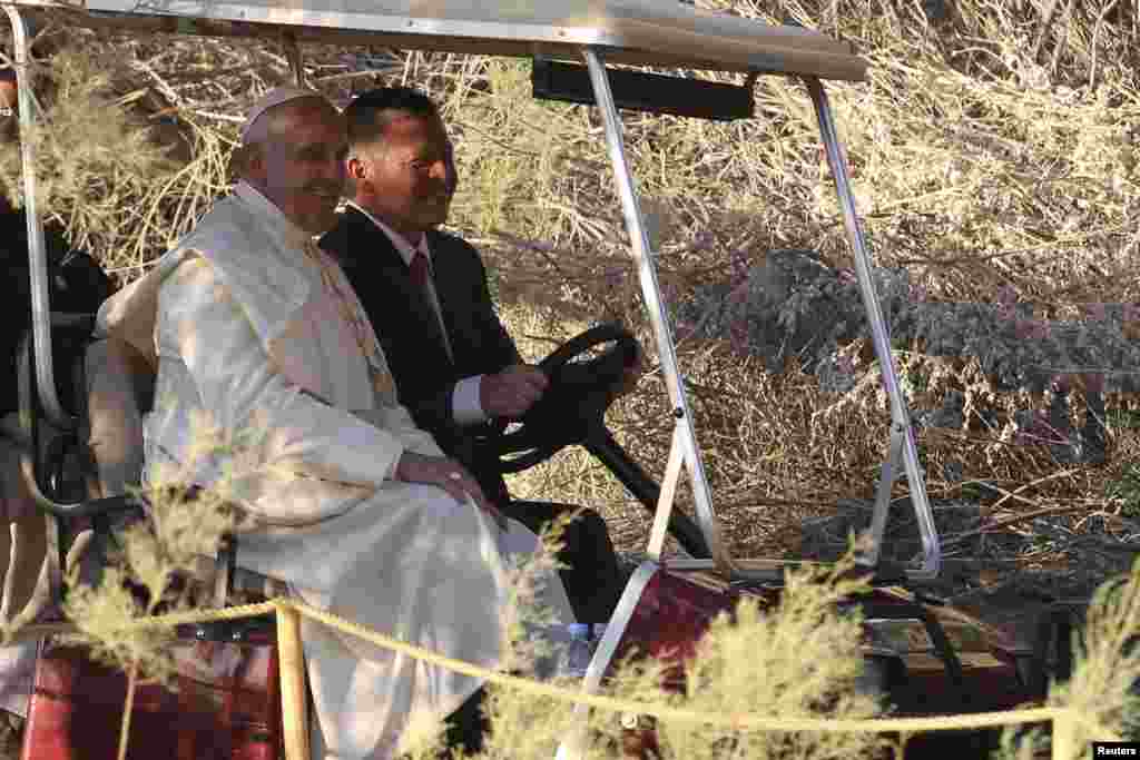 Pope Francis and King Abdullah travel in a golf cart during their visit to the site at Jordan River where Jesus is believed to have been baptized, May 24, 2014. 