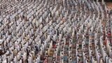 People attend Eid al-Fitr prayers to mark the end of the holy fasting month of Ramadan at a play ground in the suburb of Sale, Morocco.