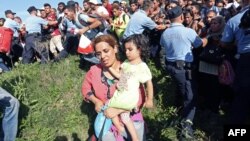 People break a police cordon as the rush to waiting buses at the train station in the city of Tovarnik, close to the Croatian-Serbian border, on Sept. 17, 2015. 