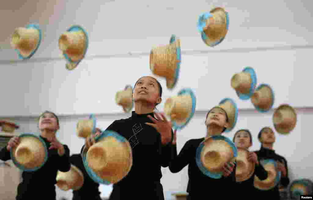 Girls juggle with straw hats at an acrobatics school in Huzhou, Zhejiang province, China.