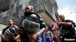 Police officers stand in front of the Petrobras headquarters during a protest in Rio de Janeiro, March 4, 2015.