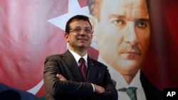 Backdropped by a poster of modern Turkey's founder, Mustafa Kemal Ataturk, Ekrem Imamoglu, the Republican People's Party's mayoral candidate in Istanbul, poses following an interview in Istanbul, April 4, 2019. 