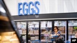 FILE - A woman buys eggs at a Walmart Superstore in Secaucus, New Jersey, July 11, 2024.