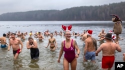 Los nadadores ingresan al agua durante la tradicional inmersión de Año Nuevo en un lago cerca de Vilnius, Lituania, el 1 de enero de 2025.