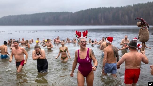 Los nadadores ingresan al agua durante la tradicional inmersión de Año Nuevo en un lago cerca de Vilnius, Lituania, el 1 de enero de 2025.