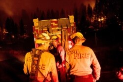 Firefighters work to stop the Sugar Fire, part of the Beckwourth Complex Fire, from spreading near Frenchman Lake in Plumas National Forest, Calif., on July 8, 2021.