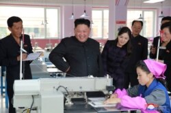 지난 2017년 10월 김정은 북한 국무위원장(가운데)과 부인 리설주(오른쪽)가 평양 류원신발공장을 시찰하는 모습을 조선중앙통신이 보도했다.